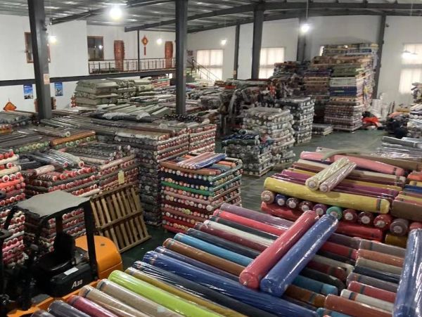Warehouse filled with colorful rolls of fabric stacked high.