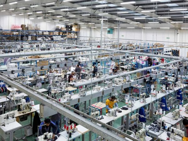 A large garment factory with many workers and sewing machines.