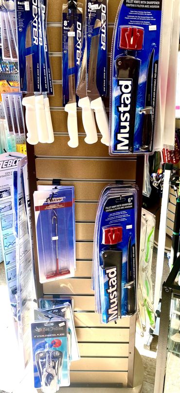 Fishing knives and tools displayed on a store rack.