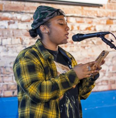 A person reading from their phone into a microphone.