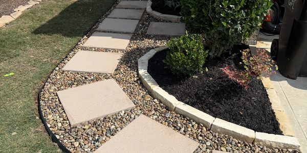 Stepping stone pathway with gravel and small garden plants.