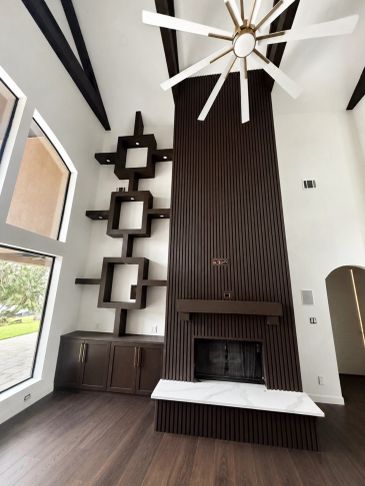 Modern living room with dark wood fireplace and shelves.