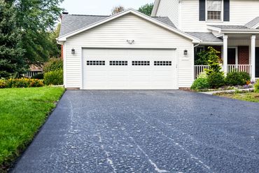 Home with newly paved asphalt driveway.