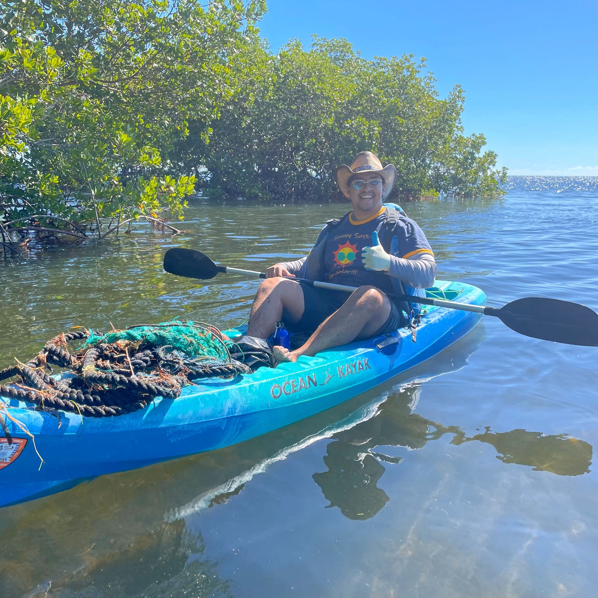 Florida Solar Partners Team member Jose helping to clean Ocean Reef canal for environmental clean up