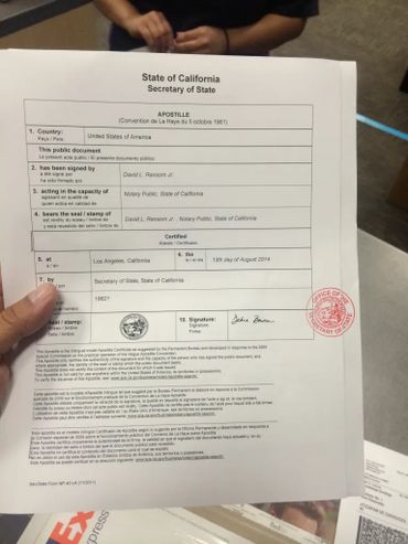 A person holding a California Secretary of State apostille document.
