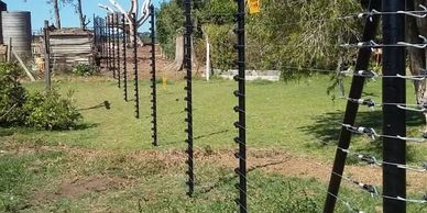 Electric fence posts on a grassy field.