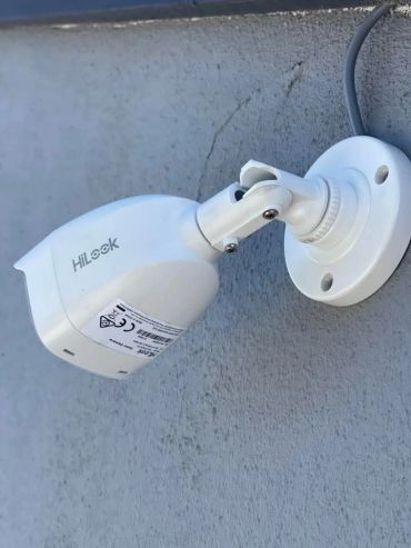 White security camera mounted on a wall.