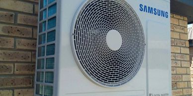 Samsung air conditioning unit mounted on a brick wall.