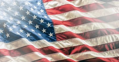 Close-up of a waving American flag with sunlight.