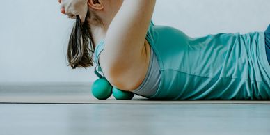 woman learning effective self massage techniques with massage balls for myofascial release.