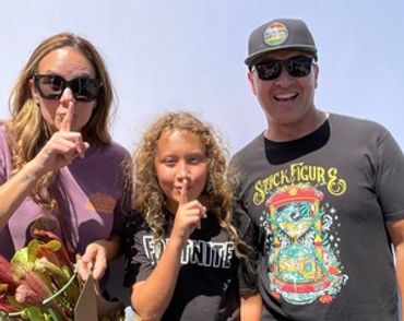 Three people posing with finger to lips in a shushing gesture.