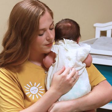 Dr Katelyn Wilson holding an infant in an office setting