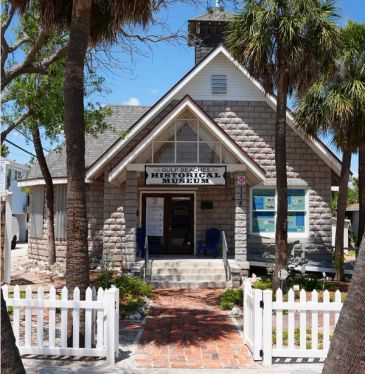 Historic museum building with a white picket fence.