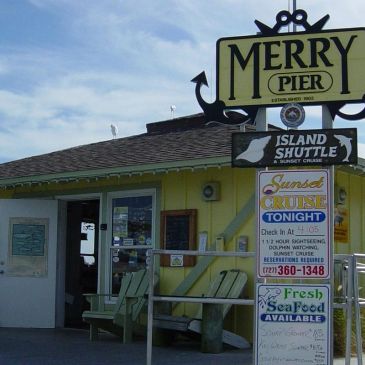 Merry Pier ticket office with shuttle and cruise signs.