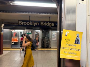 Woman in yellow dress walking in Brooklyn Bridge subway station.