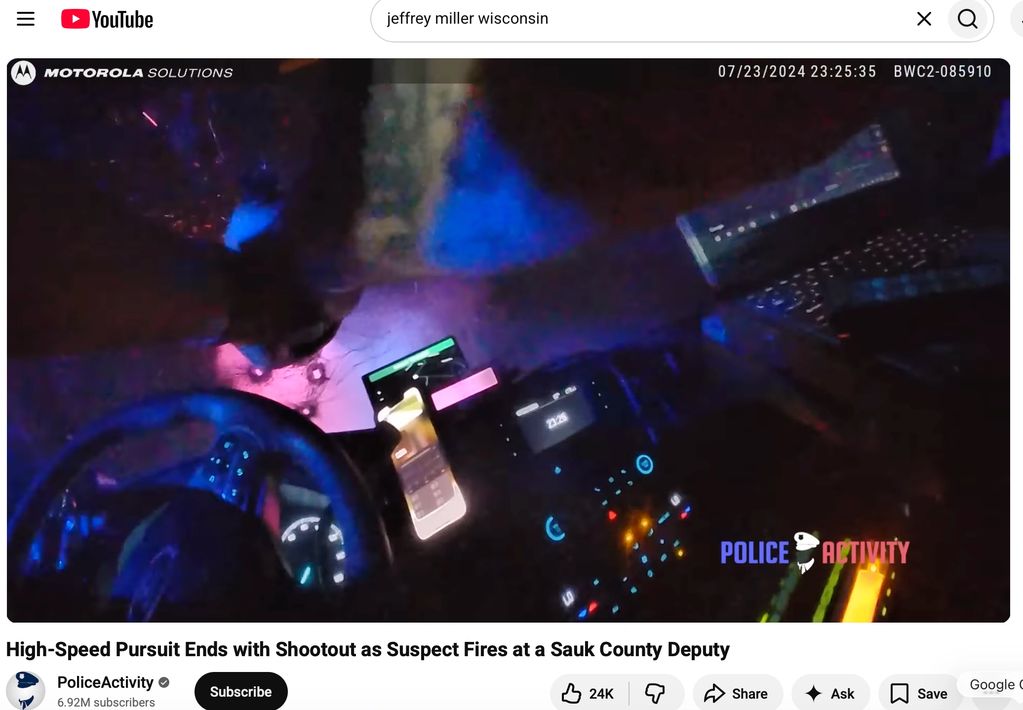 Inside a police patrol car at night showing dashboard and equipment.