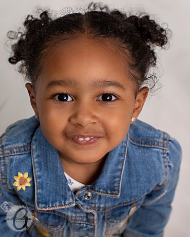 Young girl with curly hair and a jean jacket