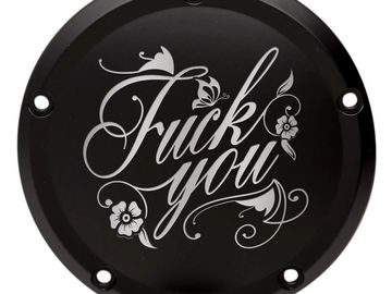 Black circular object with decorative cursive text saying 'Fuck you'.