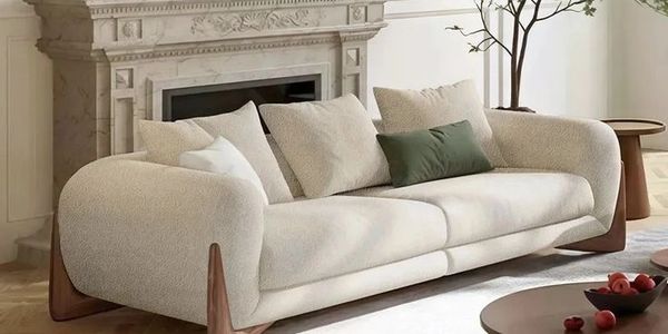 Modern beige sofa with wooden accents and cushions in a stylish living room.