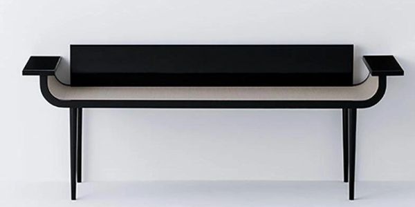 Modern black bench with angled legs and raised armrests against a white wall.