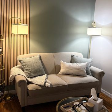 Cozy beige sofa with cushions in a softly lit room.