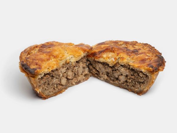 A halved savoury meat pie with a flaky, golden-brown crust and a densely packed meat filling.