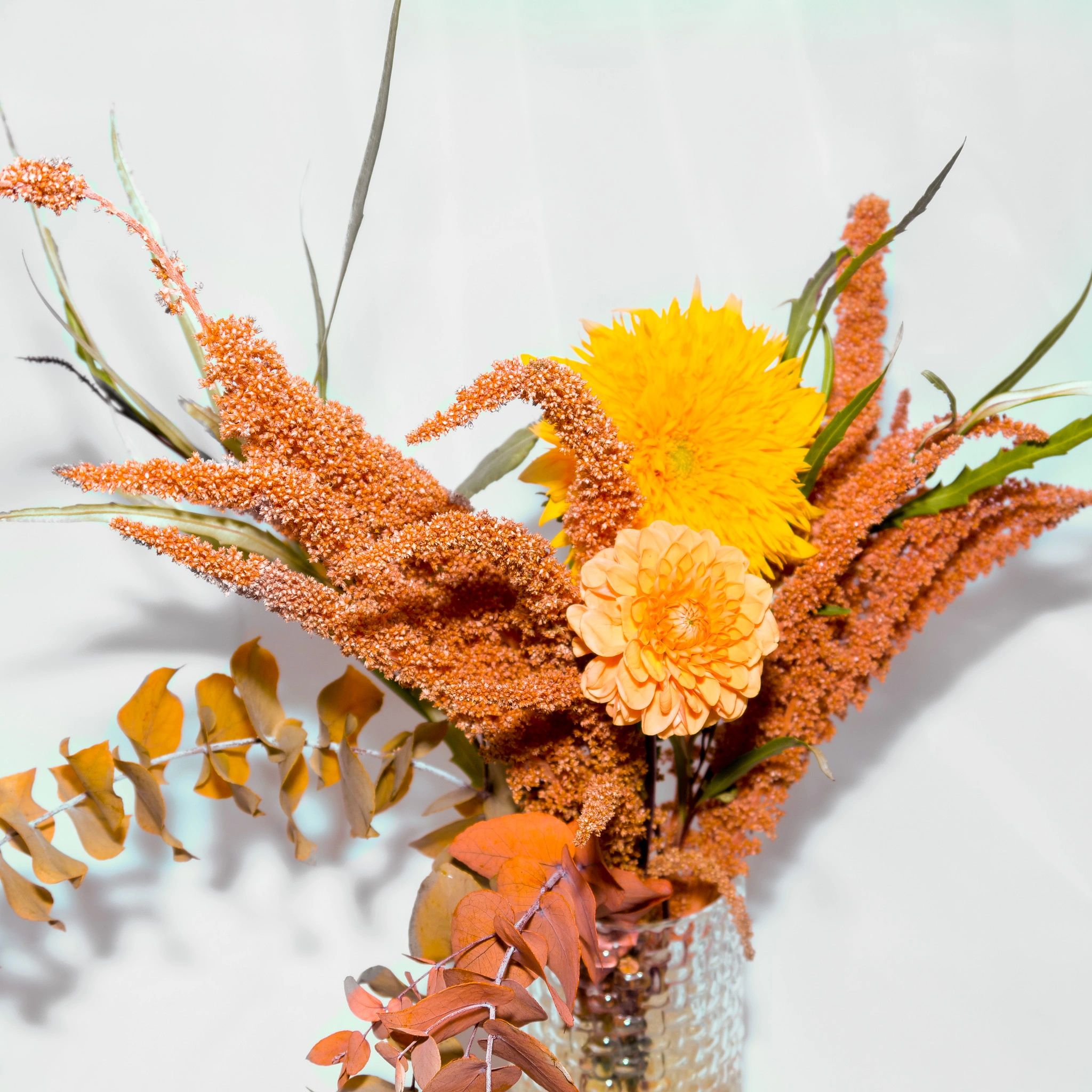 yellow and orange flowers bouquet in a clear glass vase