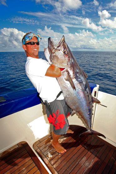 happy Moorea sport fishing guest with big dog tooth tuna