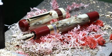 Elegant marbled fountain pen with red accents on decorative shavings.