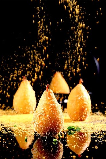 Golden, crispy fried snacks with a sprinkle of crumbs falling over them.