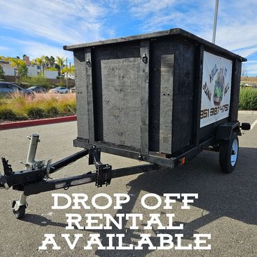 Black wooden utility trailer with rental service signage in a parking lot.