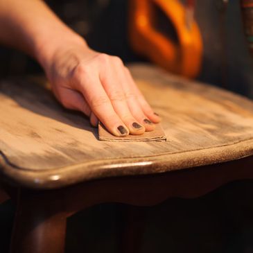 A professional using sandpaper on a table