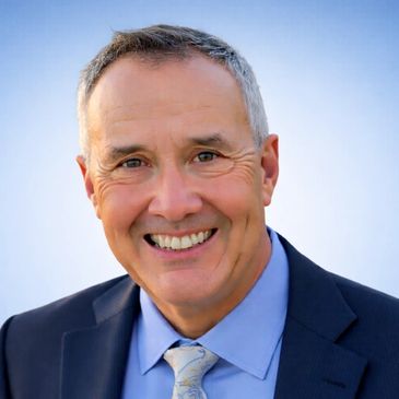 Smiling middle-aged man in suit and tie.