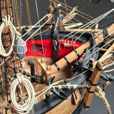 Close-up of a detailed ship model with ropes and anchor.