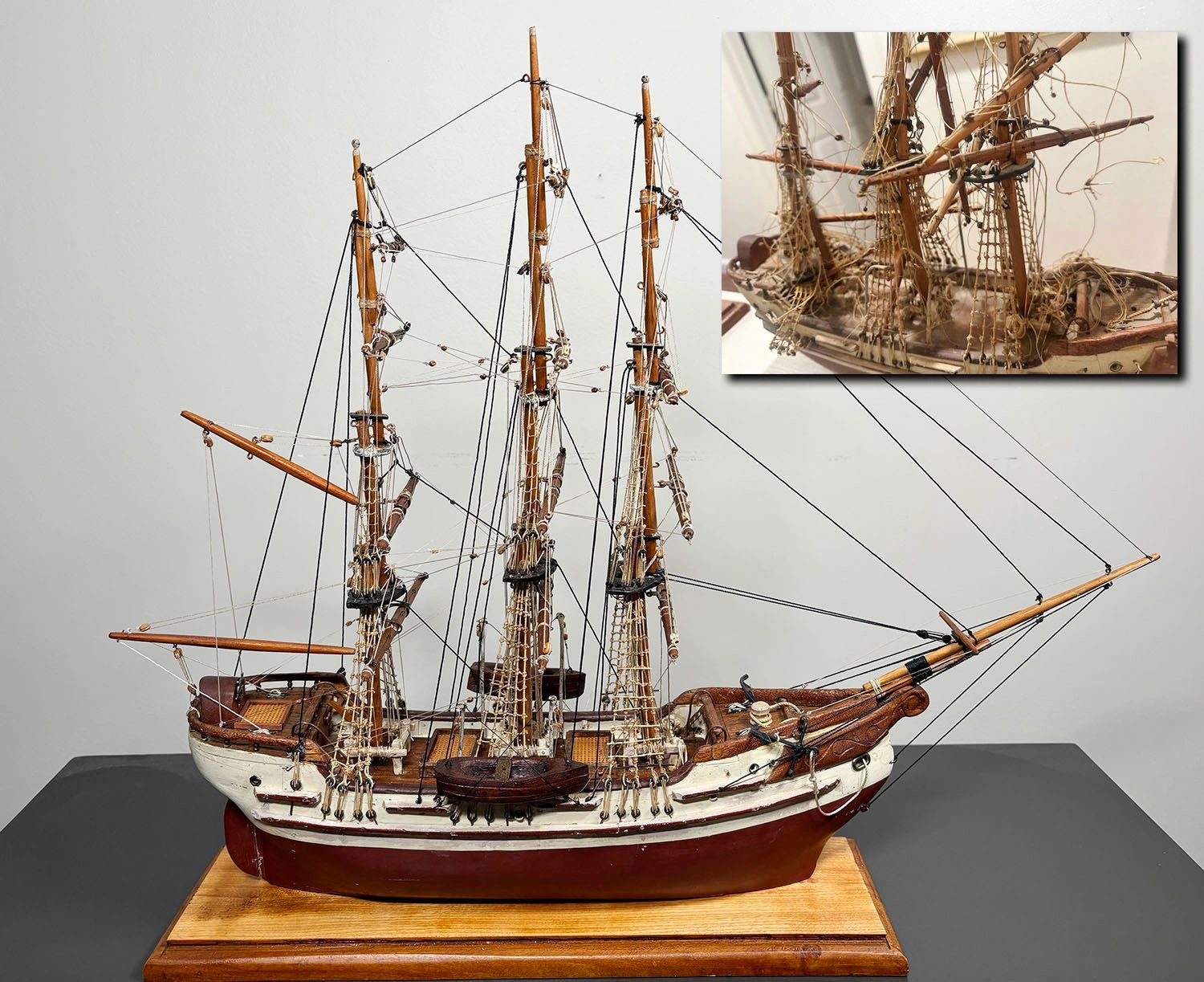 Detailed model ship with intricate rigging on wooden stand.