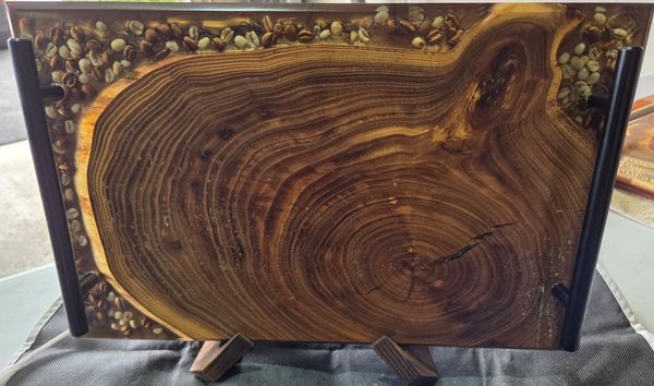 Polished wood slab with natural rings framed by embedded coffee beans
