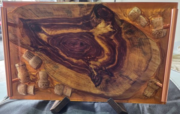 Wooden tray with natural wood grain and wine corks as decoration.