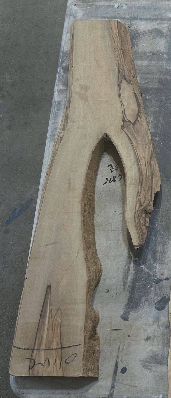 Irregular wooden plank with natural edges on a workbench.