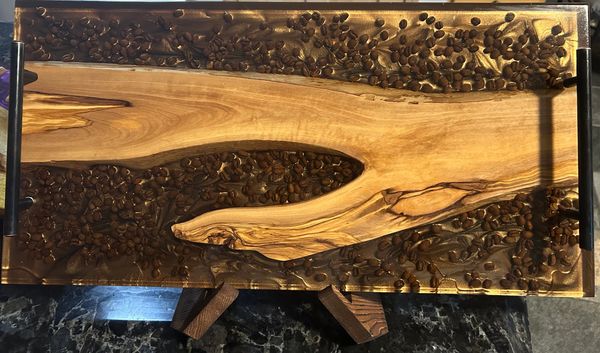 Wooden tray with embedded coffee beans and black handles.