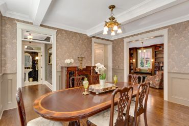 Elegant dining room with floral wallpaper and vintage furniture.