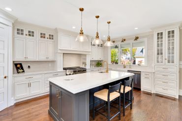 Elegant kitchen with white cabinets and dark island.