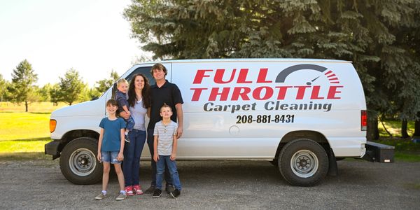 A family stands together beside a Full Throttle Carpet Cleaning van.