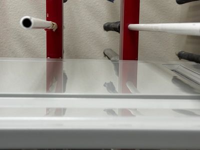 Close-up of a whiteboard with red supports and markers.