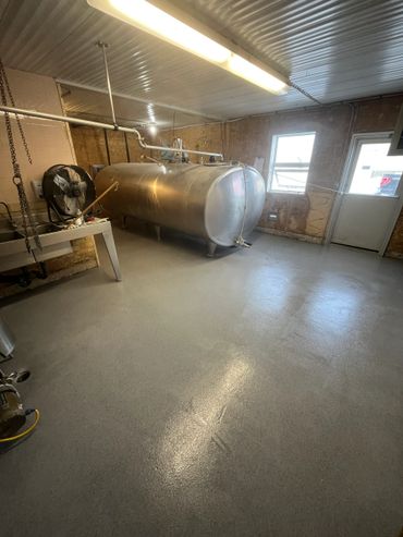 Industrial room with a large metal tank and concrete floor.