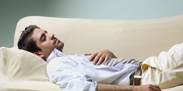 A young men taking a nap on a couch