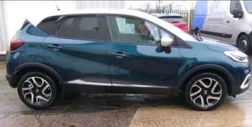Side view of a modern two-tone compact SUV parked on wet pavement.