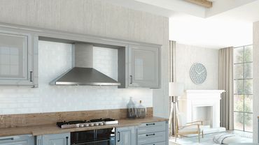 Bright modern kitchen with gray cabinets and wooden countertops.