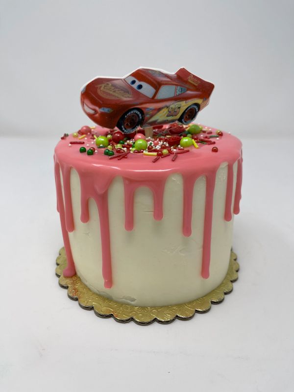 White cake with pink drip and red race car