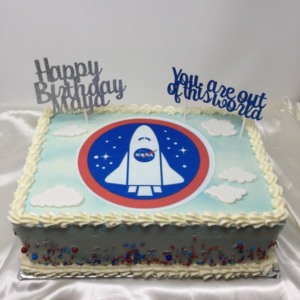 blue cake with white clouds and NASA rocket on top