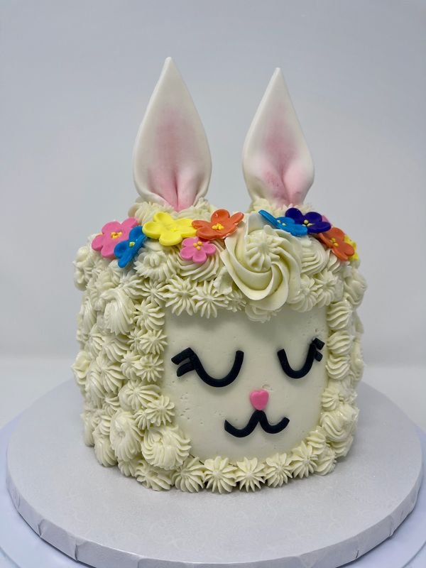 Llama face cake with rosette fur and multicolored flowers on the top